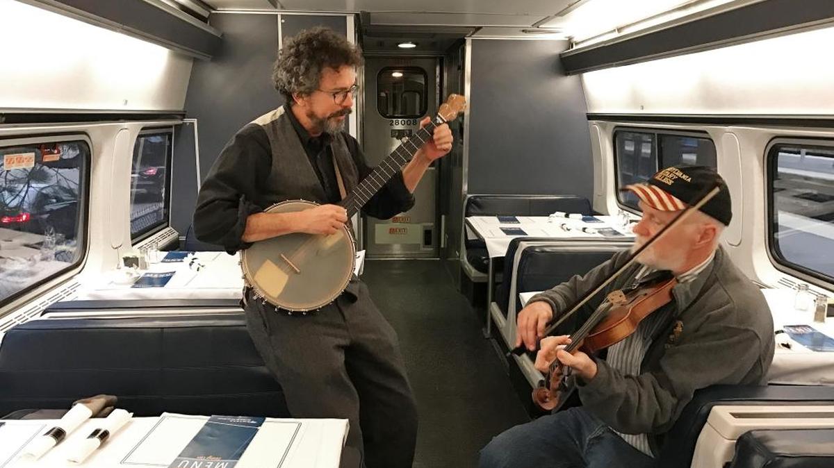 Paul Draper, 59, of Voorheesville, N.Y., left, and 63-year-old Mike Jarboe of Clifton Park, play music on the train north of New York City. They were on their way