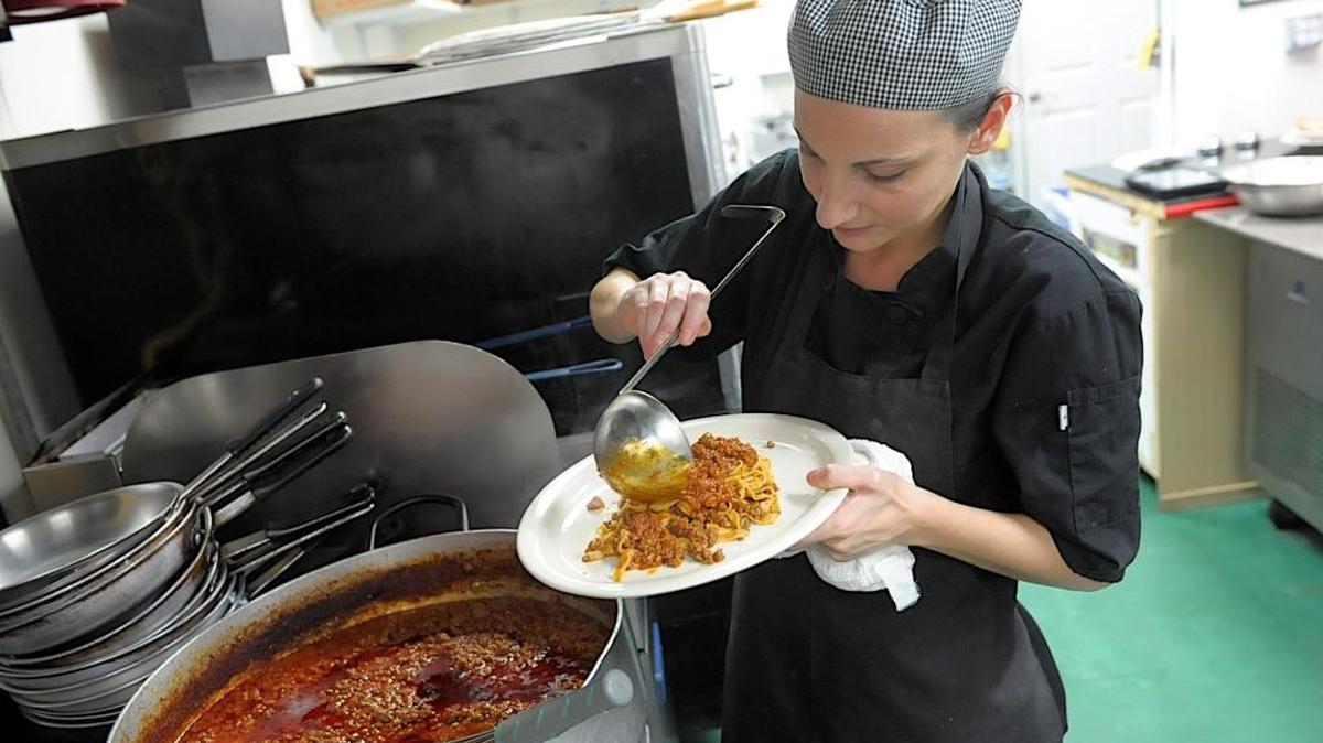 Monica Cecconi, along with her husband and Tiramisu Ristorante & Pizzeria co-owner Luca Cecconi, tops a plate of homemade Tagliatelle pasta with slow-simmering Bolognese sauce at their restaurant in Bradenton.