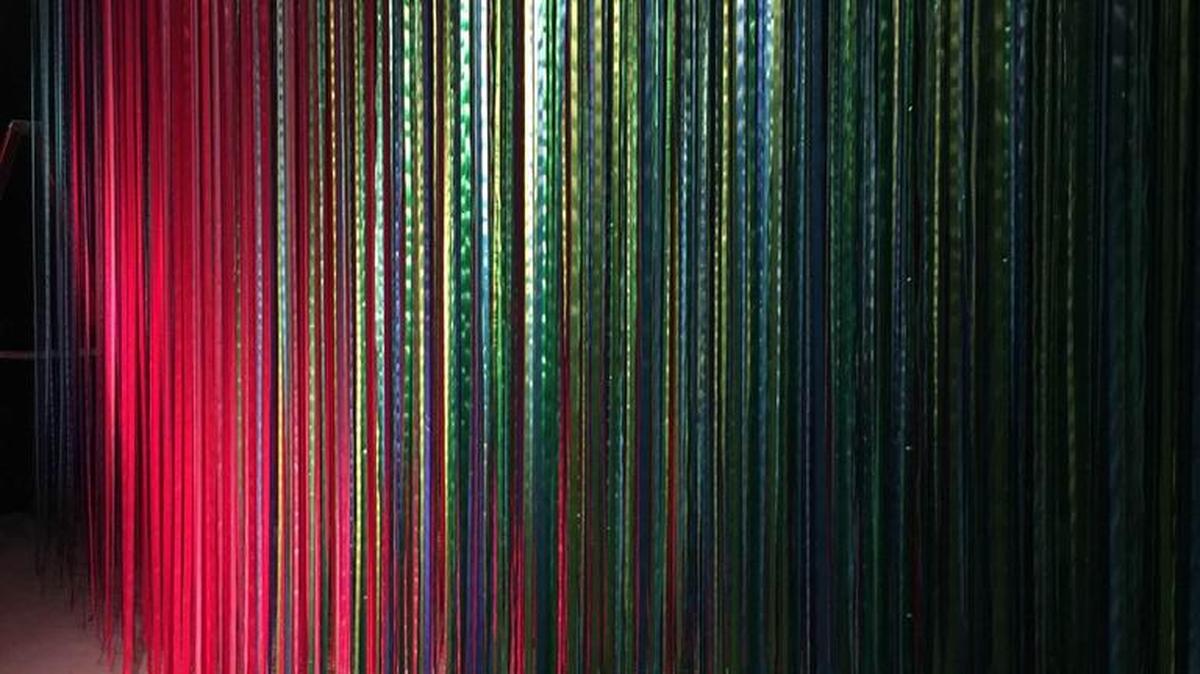 “Pathless Woods,” an installation by artist Anne Patterson, is immersive and interactive, and involves four of the five senses. Visitors will touch the ribbons as they walk through the spectrum of colors, from the deep hues of the ribbons at the entry way to a bright red area at the the center.