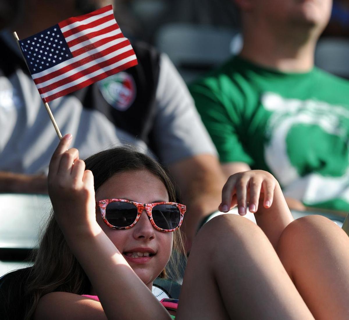 Jenna Knapik waves a small flag during a Fourth of July Marauders game at McKechnie Field.