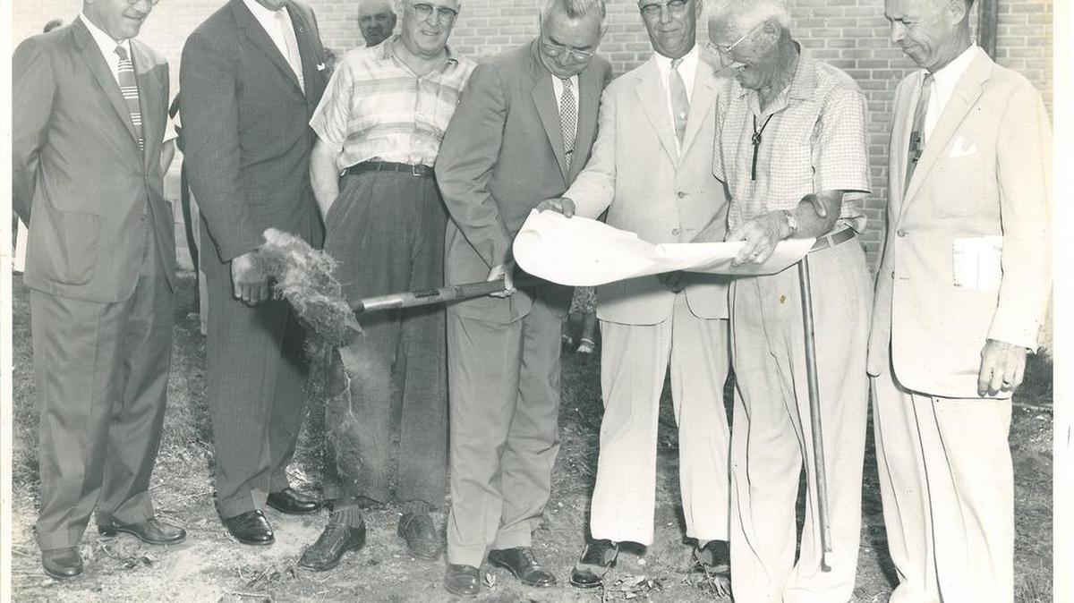 Officials look over plans for the art center at the groundbreaking ceremony. Photos such as these will be part of an exhibit on center history.