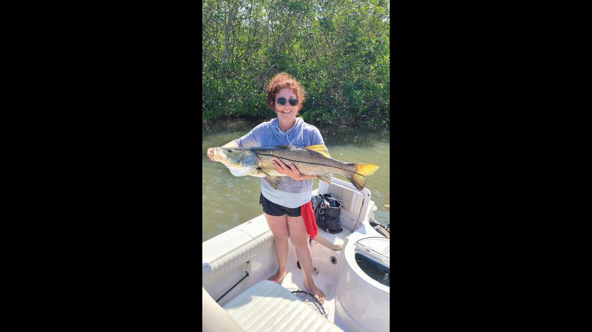 Tanya Johnson poses with the 42-inch snook she caught fishing in Tampa Bay with Capt. Anthony Rufo on Wednesday, March 29, 2023.