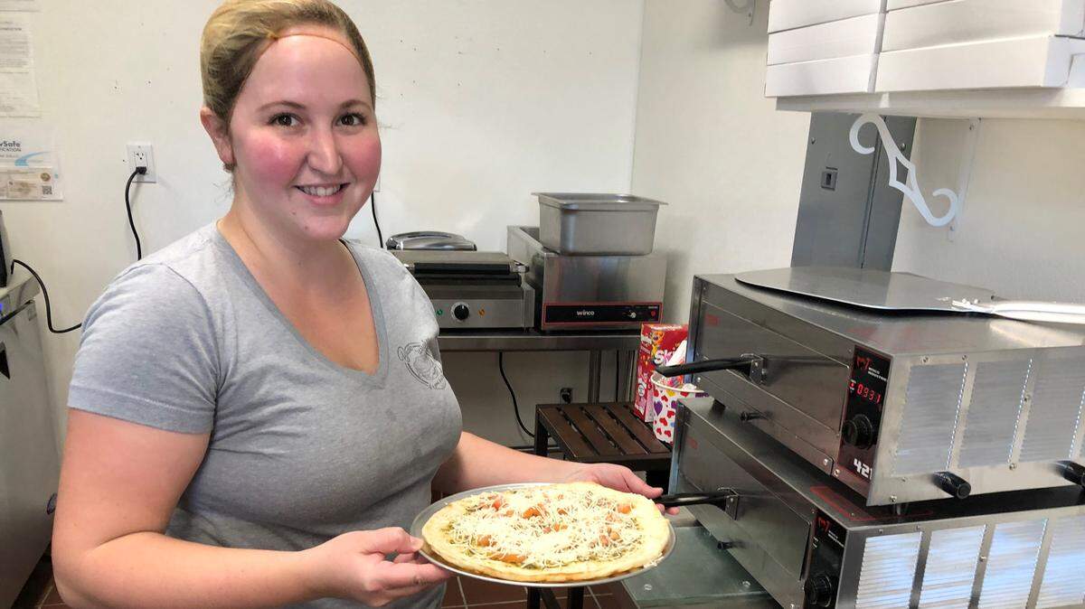 Rhianna Walters prepares to pop a flatbread into the oven at Basic ‘Wiches deli, which opened recently in unit 130 of 119 Bridge Street, Bradenton Beach.