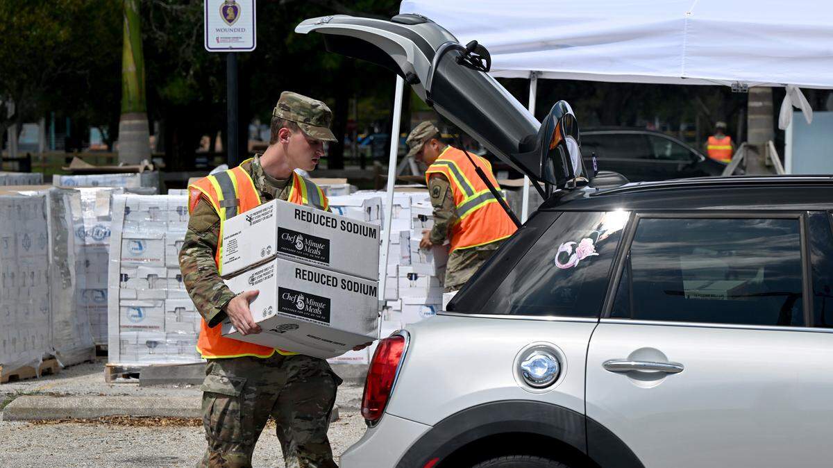 Members of the Army Florida National Guard, 3-116 B Battery Field Artillery group work at the G.T. Bray Park distribution center handing out water, tarps and MRE’s to residents affected by Hurricane Helene.