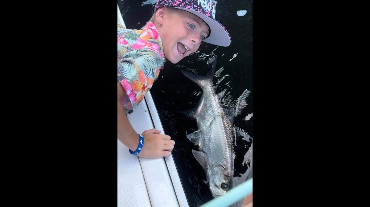 A boy on a recent trip with captain Griffin Deans smiles as the group reeled in a tarpon while fishing in Tampa Bay.