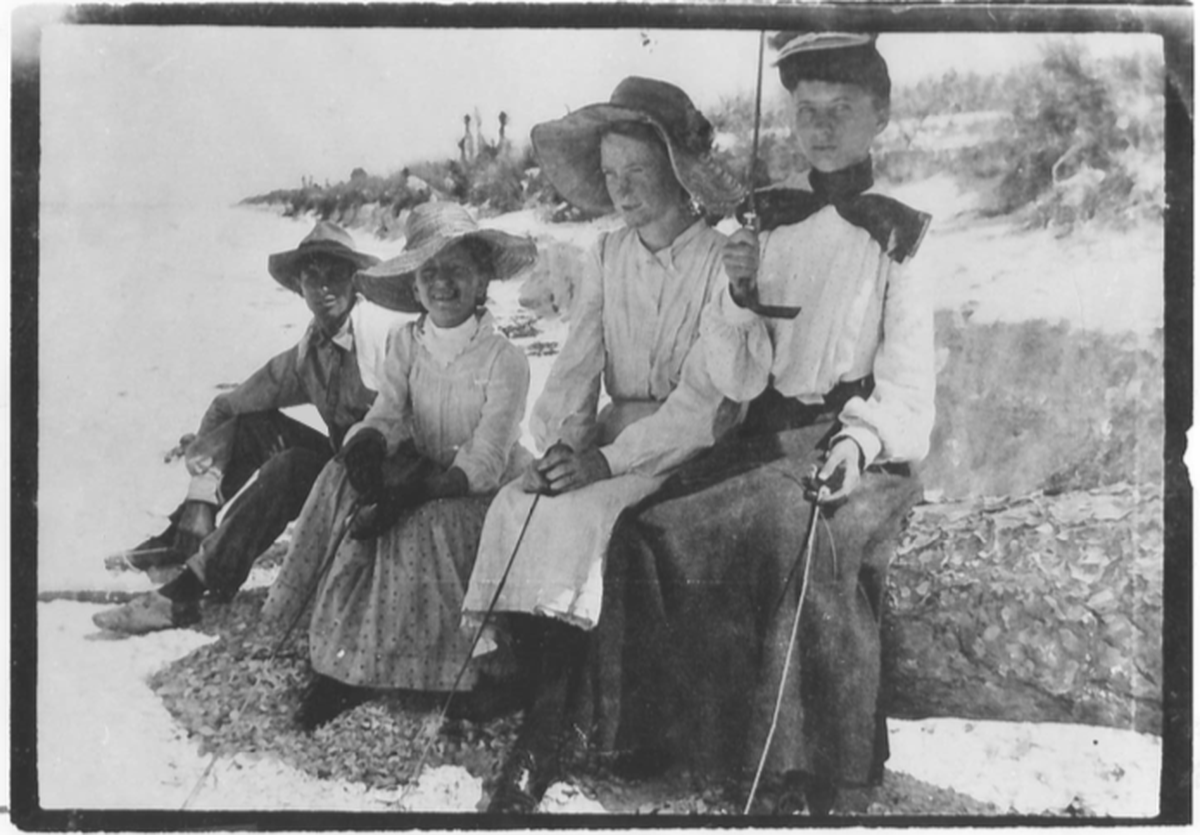Beachgoers don conservative beachwear in the early 1900s.