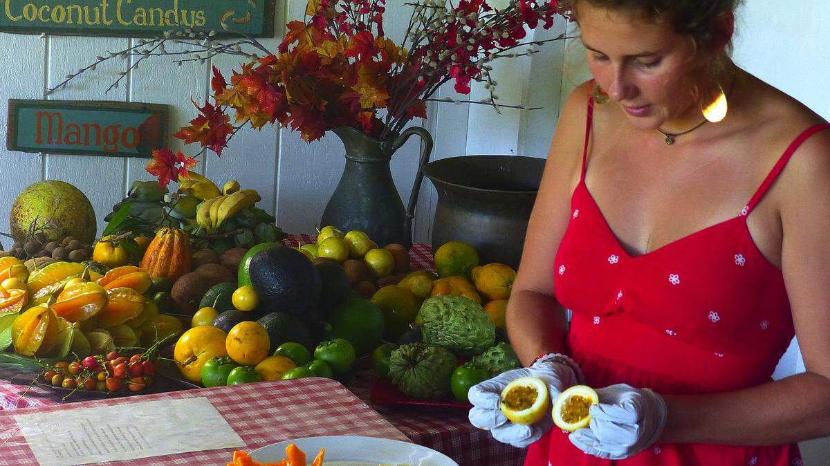 Tour guide Maria Sadusky shows off a lilikoi (passion fruit), ready to eat, at Ono Farms near Hana on the Hawaiian island of Maui. The tour of Hawaii's largest organic farm includes tastings of at least a dozen tropical fruits, such as those seen in the background. (Brian J. Cantwell/Seattle Times/TNS)