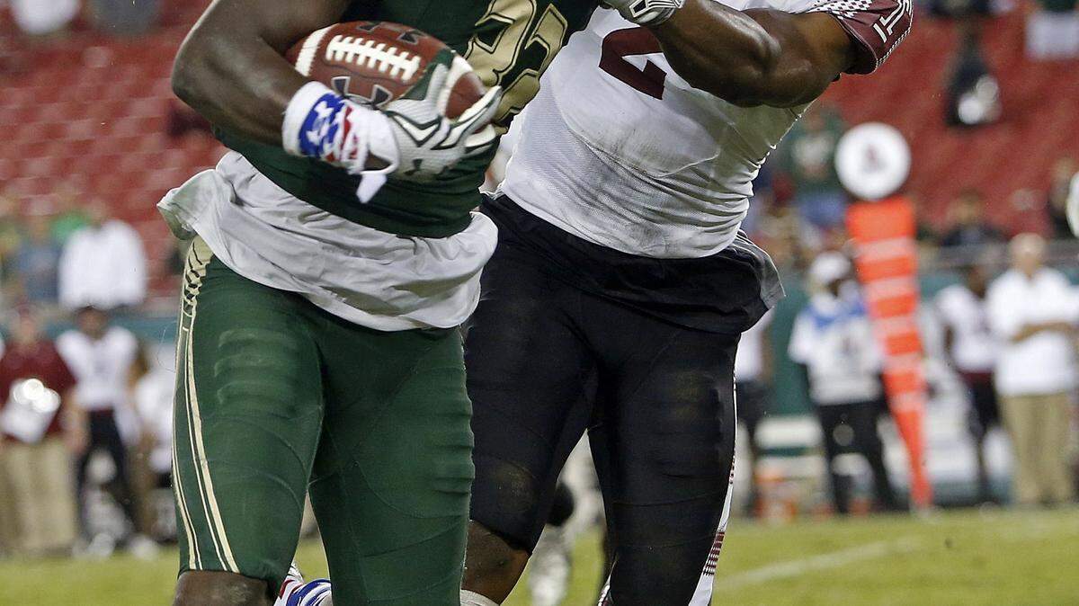 USF running back D'Ernest Johnson (32) fends off Temple linebacker Avery Williams on Saturday at Raymond James Stadium. ASSOCIATED PRESS