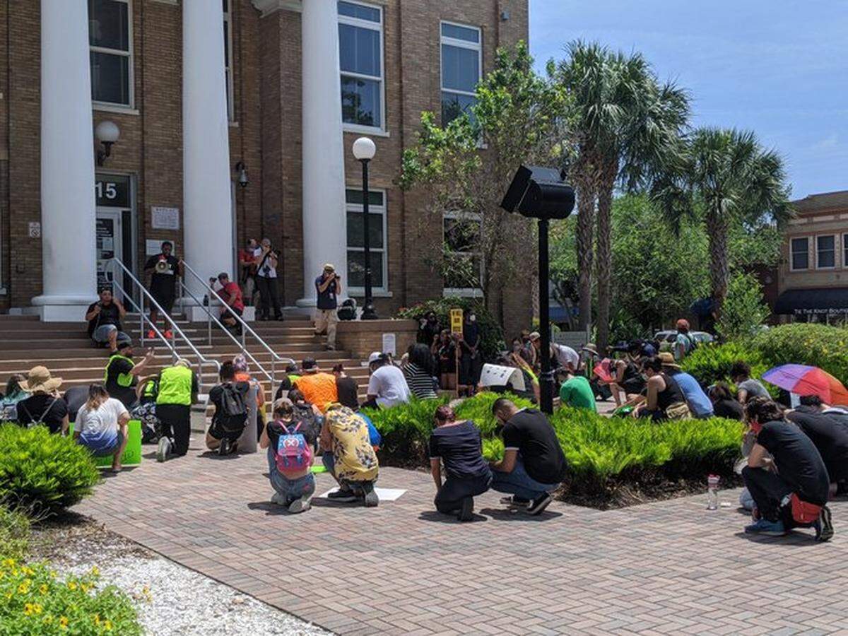 Protesters take a knee in silence at the steps of the Manatee County Courthouse for 9 minutes in honor of GeorgeFloyd as pastor speaks.