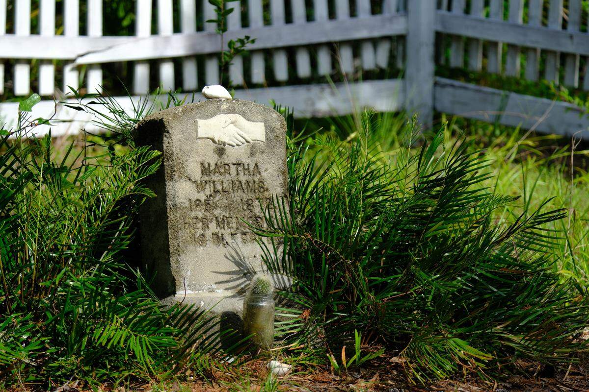 Manatee County is using voter-approved conservation funds to purchase 4.5 acres of forested land around the Rye Cemetery and Rye Preserve in Parrish to shield the area from future development. A headstone is pictured at the cemetery on June 18, 2025.