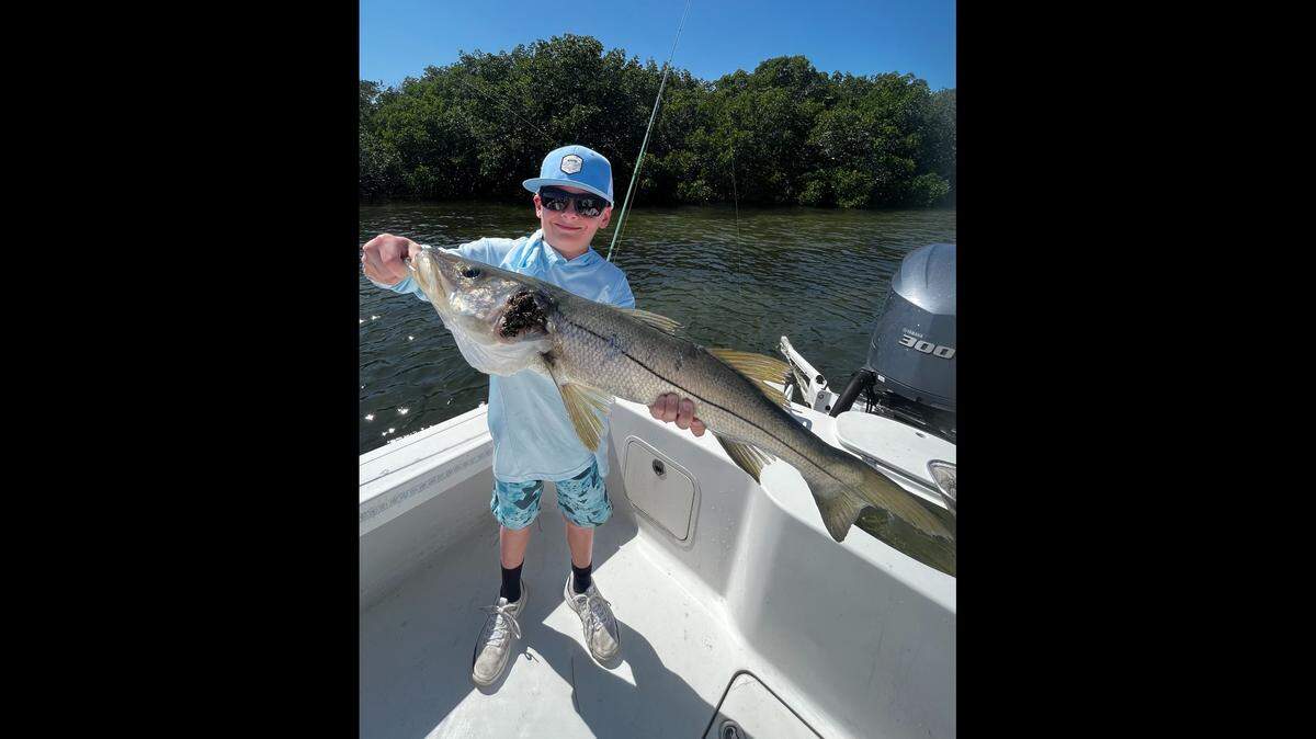 Keller Nelson, 10, poses with a snook he recently caught fishing in Miguey Bay off of Terra Ceia with Palmetto-based Captain Griffin Deans.
