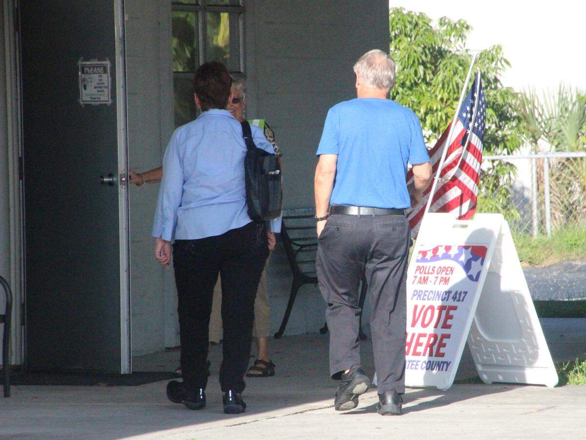 A precinct worker welcomes voters to the polls on Tuesday at Oneco United Methodist Church, which serves as Precinct 417 at 2112 53rd Ave. E.