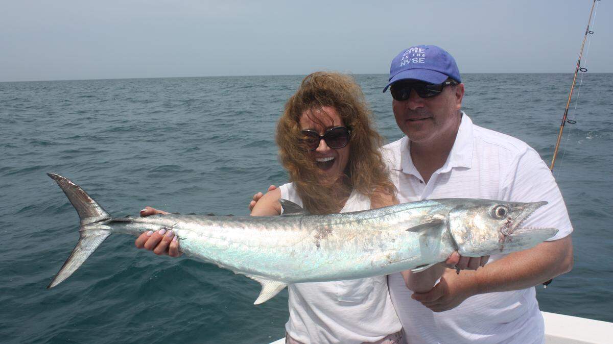 Kari Deanaleos is assisted by Jim Deanaleos with a smoker kingfish she caught with a sardine in about 45 feet offshore of Anna Maria Island. 
 PHOTO PROVIDED