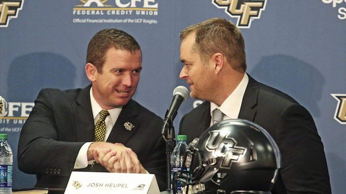 In this file photo, Josh Heupel, right, is introduced as the new Central Florida head football coach by Danny White, UCF Athletic director in Orlando, Fla., Tuesday, Dec. 5, 2017.