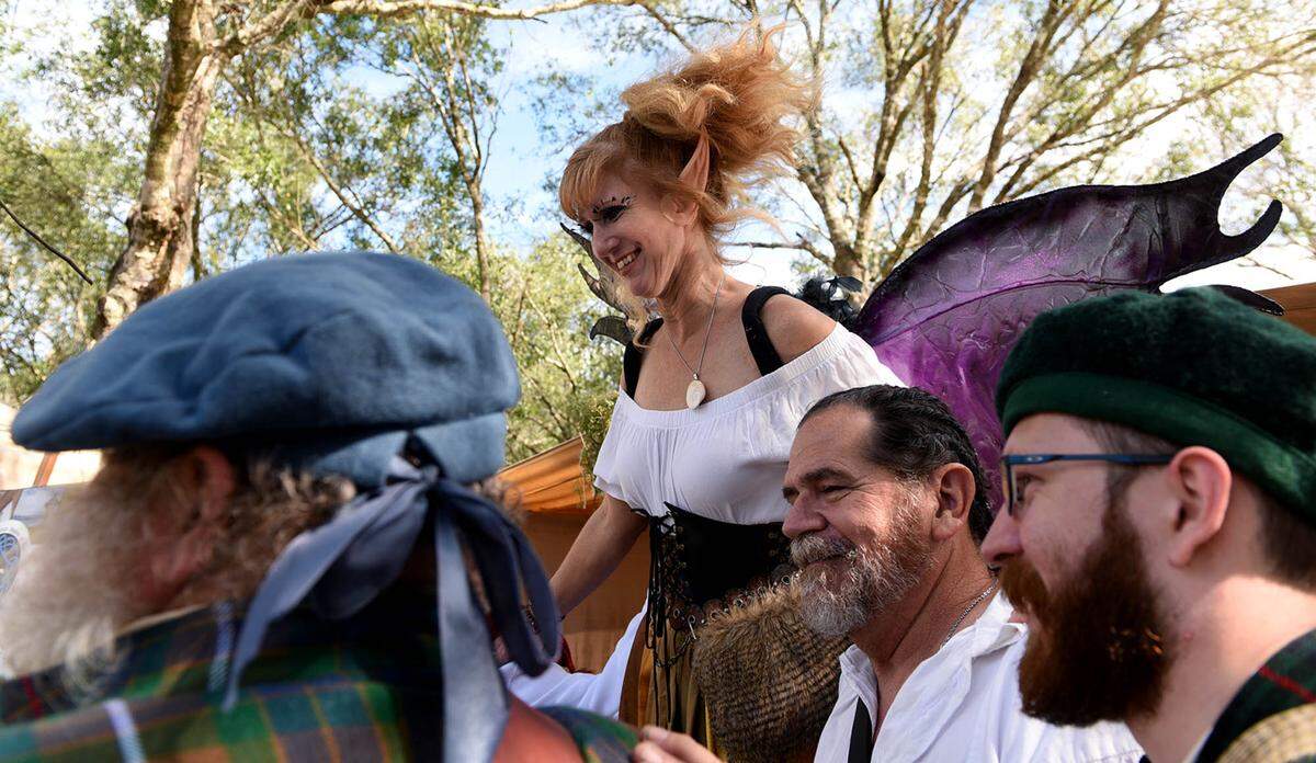 11/14/21—Althea Tew, dressed as a fairy, poses with some visitors at the Sarasota Medieval Fair in Myakka Sunday.