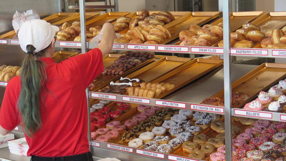 An employee grabs fresh doughnuts for a customer at the recently opened Shipley Do-Nuts location at 6571 State Road 70 E. in Bradenton. The restaurant opened June 25 and is the first franchise location in Florida.
