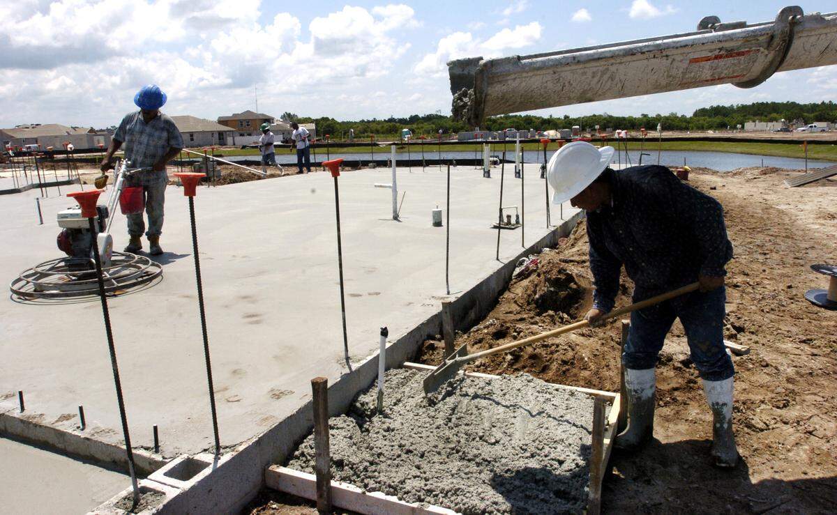 Construction workers smooth out concrete for a new home being built in Lakewood Ranch.