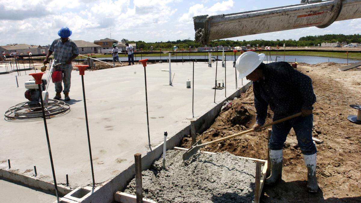 Construction workers smooth out concrete for a new home being built in Lakewood Ranch.
