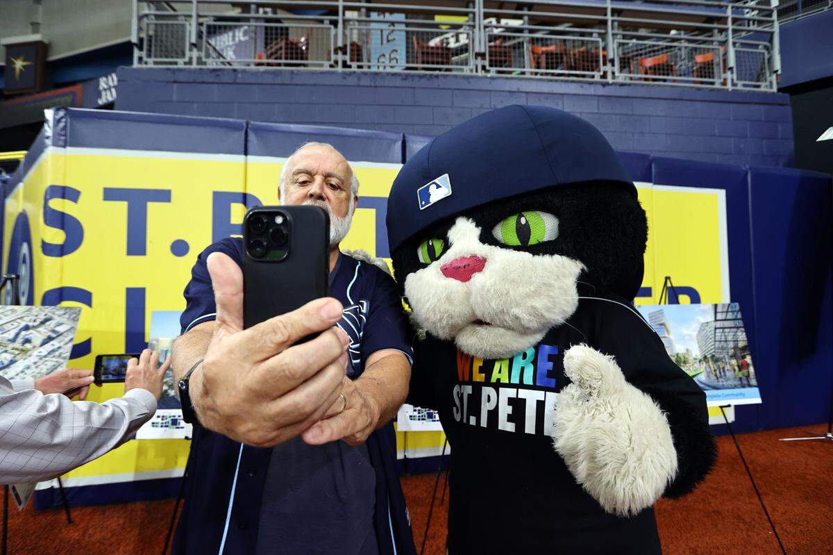 Tampa Bay Rays fans take photo with mascot, DJ Kitty, after Tuesday’s press conference announcing the plans for new $1.3 billion stadium in St. Petersburg at Tropicana Field.