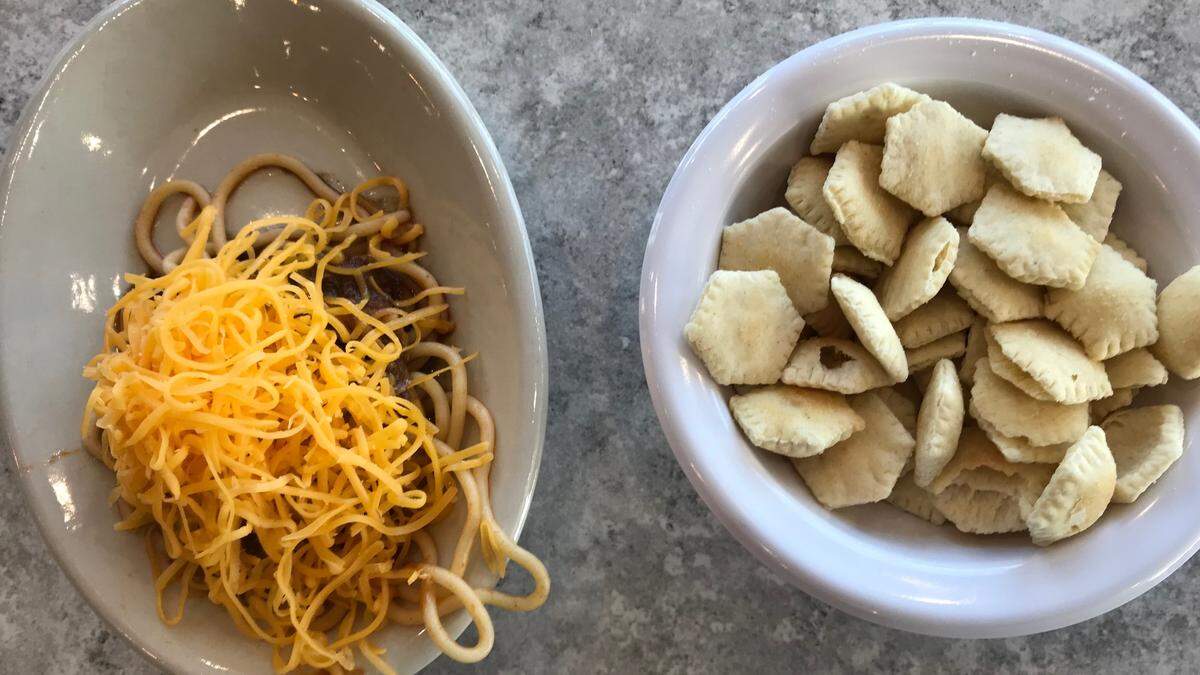 A “Three Way” is a tasty dish of spaghetti topped with chili and cheddar, and it’s eaten longwise like a slice of pie.