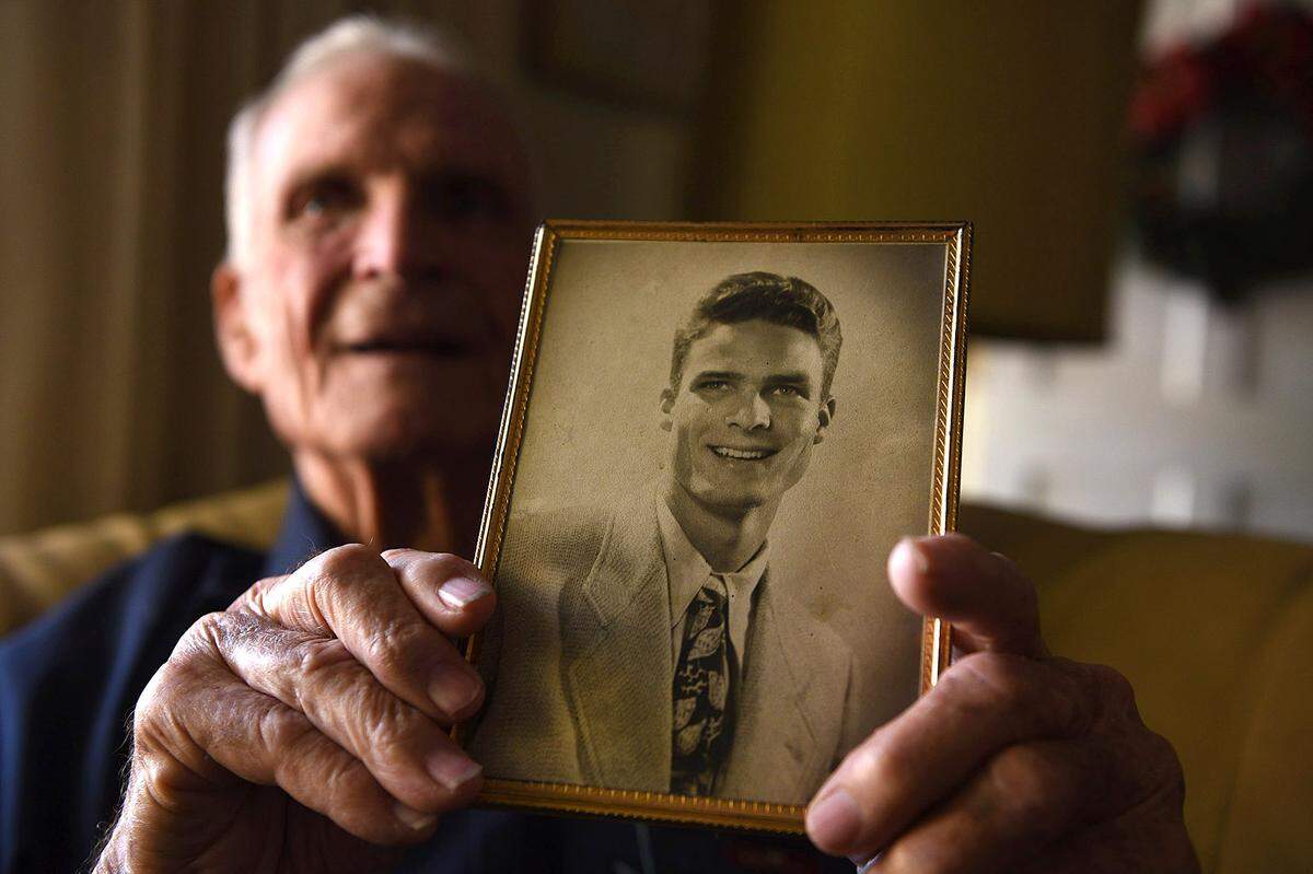 12/06/21—Charles Jones, 93, holds a photograph of himself when he was a teen in Manatee High School. He was just 13 when the Japanese bombed Pearl Harbor.