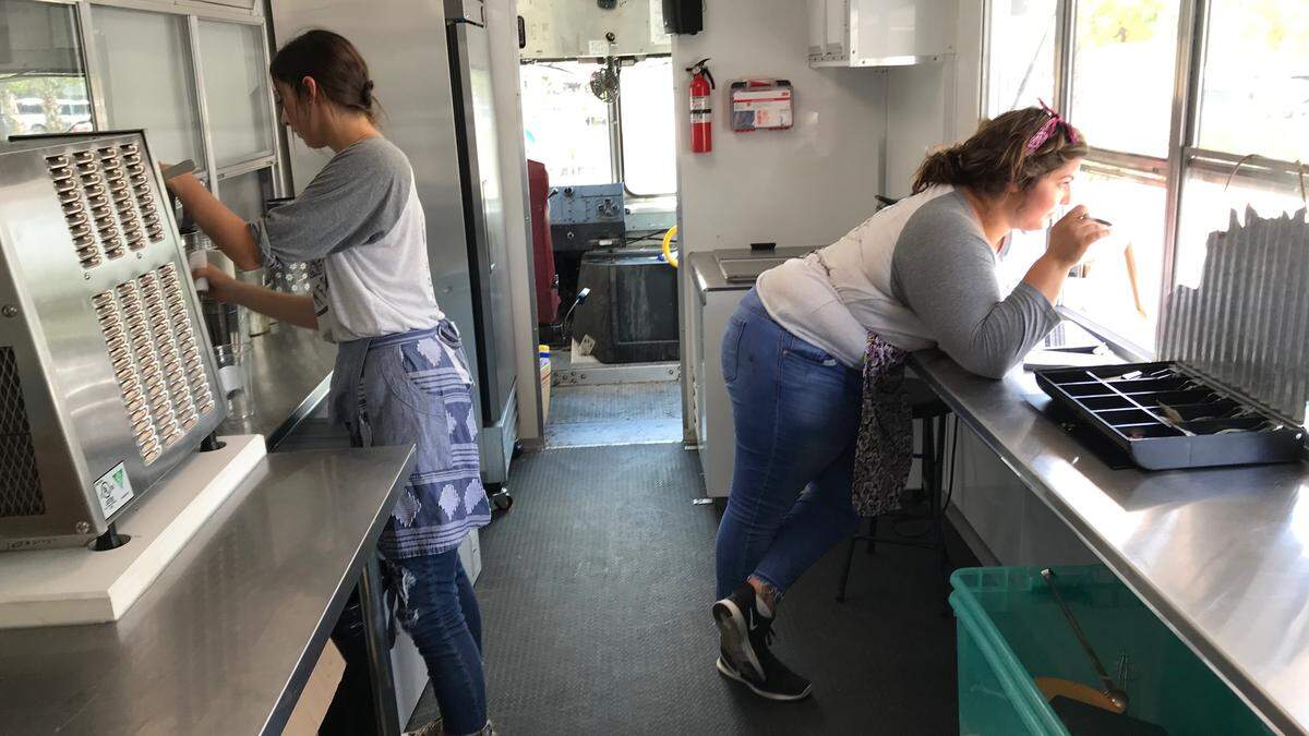 Ali, left, and Mindy Converse, right, wait on customers from their ice cream truck parked at The Home Depot,  5820 State Road 64 E.