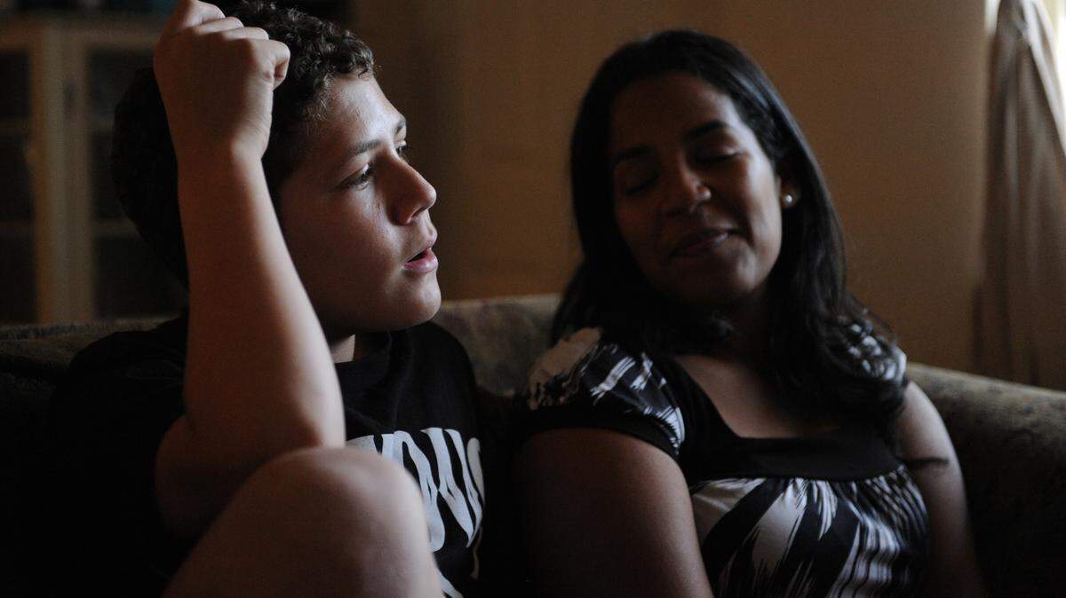 Evan England, 11, sits with his mother, Jissel Shoemaker, at their home in Bradenton. Evan has attention-deficit hyperactivity disorder and is taking part in a new treatment study that uses special video games to treat the condition. 
 GRANT JEFFERIES/Bradenton Herald