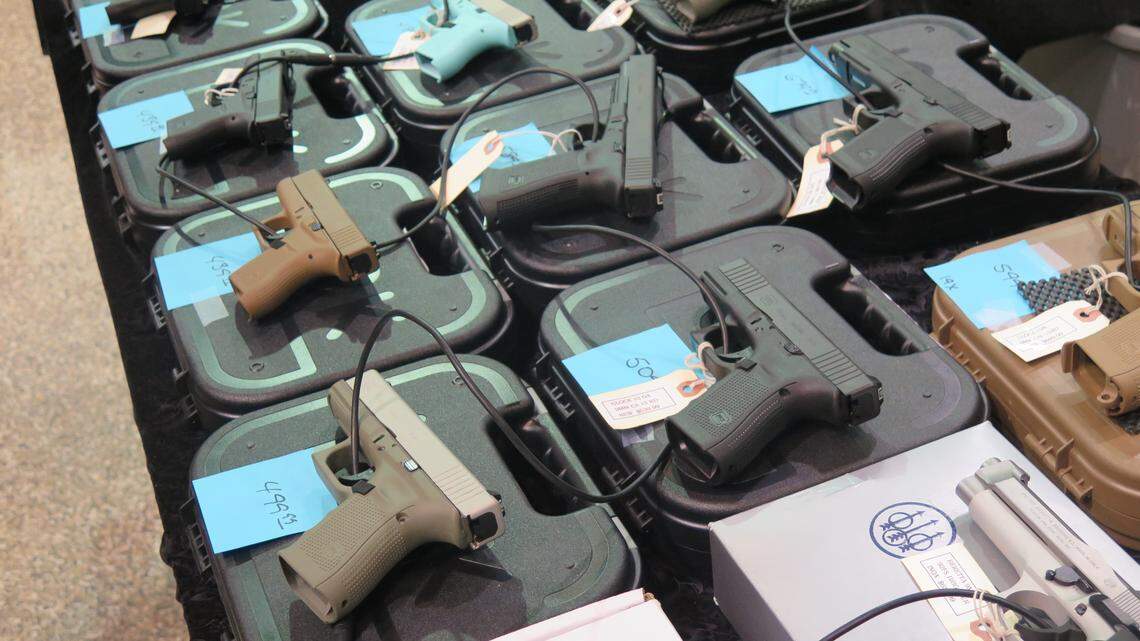 An array of handguns is displayed on a table at the Florida Gun Show in the Bradenton Area Convention Center in 2018.