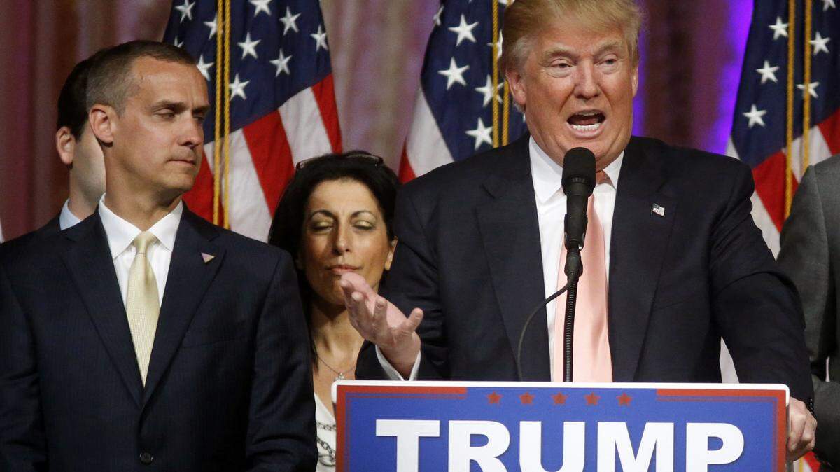 FILE - -In this March 15, 2016 file photo, Donald Trump's campaign manager Corey Lewandowski listens at left are Trump speaks in Palm Beach, Fla. Florida police have charged Lewandowski with simple battery in connection with an incident earlier in the month involving a reporter. (AP Photo/Gerald Herbert, File)
