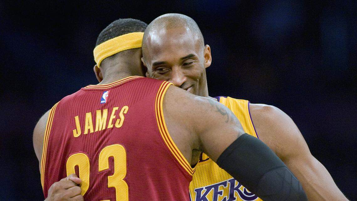 In this Jan. 15, 2015, file photo, Los Angeles Lakers guard Kobe Bryant, right, and Cleveland Cavaliers forward LeBron James hug before the start of an NBA basketball game in Los Angeles.