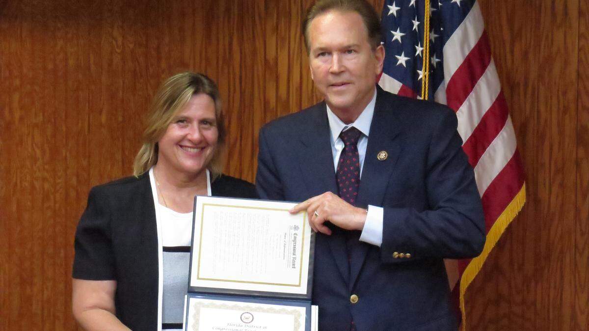 Charlotte Latham, 56, of Manatee County, smiles with Rep. Vern Buchanan at the Congressional Teacher Awards ceremony in Sarasota on March 18, 2016.AMARIS CASTILLO/Bradenton Herald
