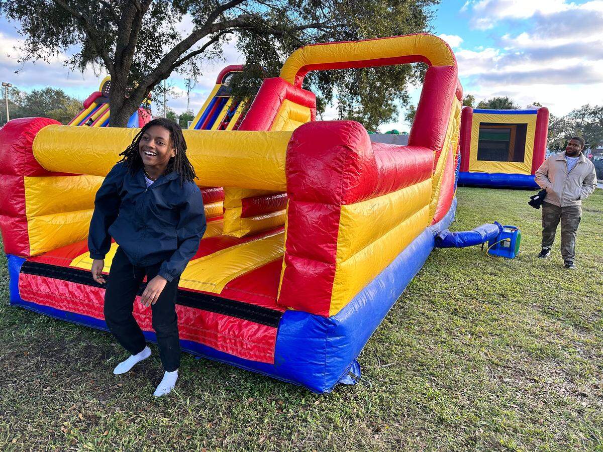 Kyra Revange exits a bounce slide with her dad Tyree Revange not too far behind at the Multicultural Festival in Palmetto on on Saturday, Jan. 14, 2023. Earlier that day, the two threw out candy and beads during the Martin Luther King Jr. Parade they were in with their church.