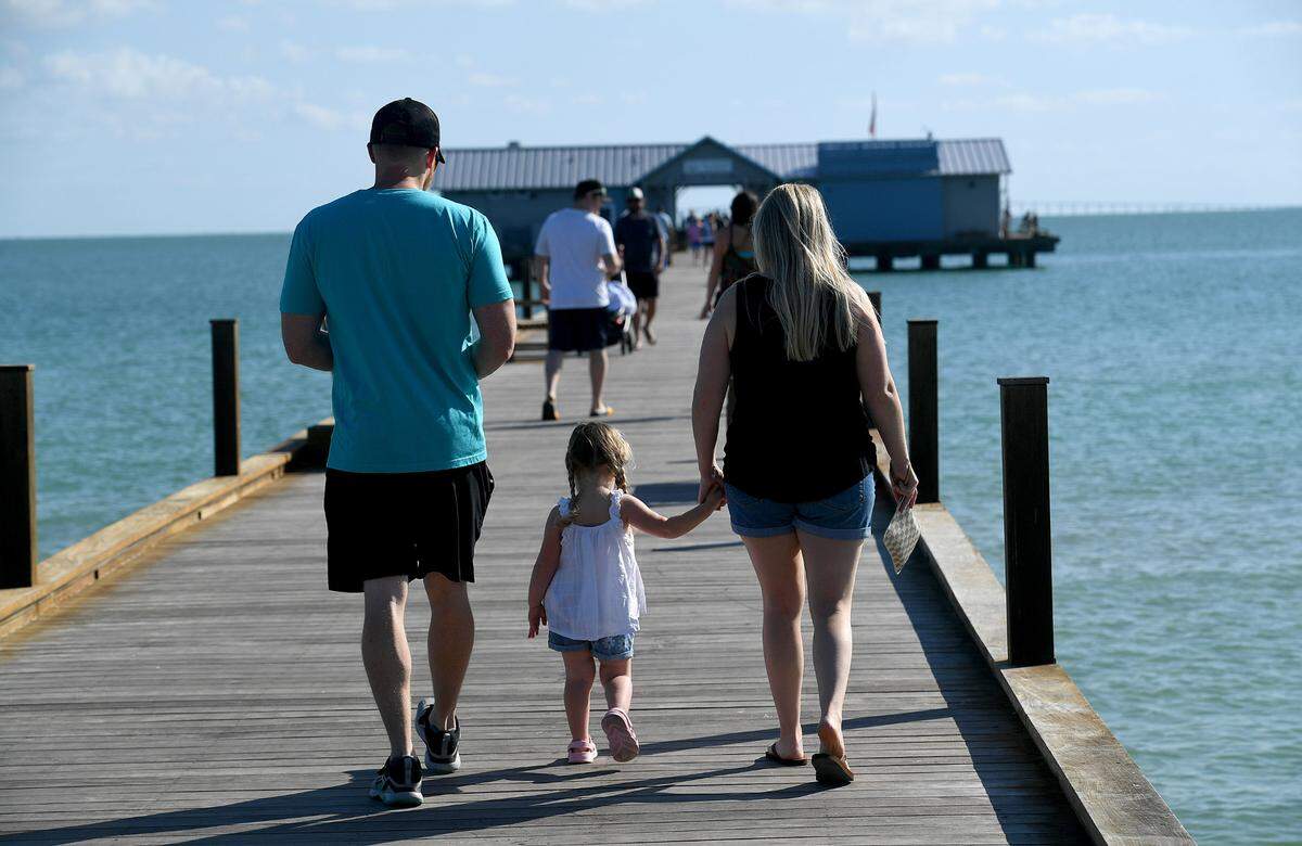 A family walks along the Anna Maria Pier where Mote Marine Laboratory & Aquarium opens its Anna Maria outreach and education center this week.