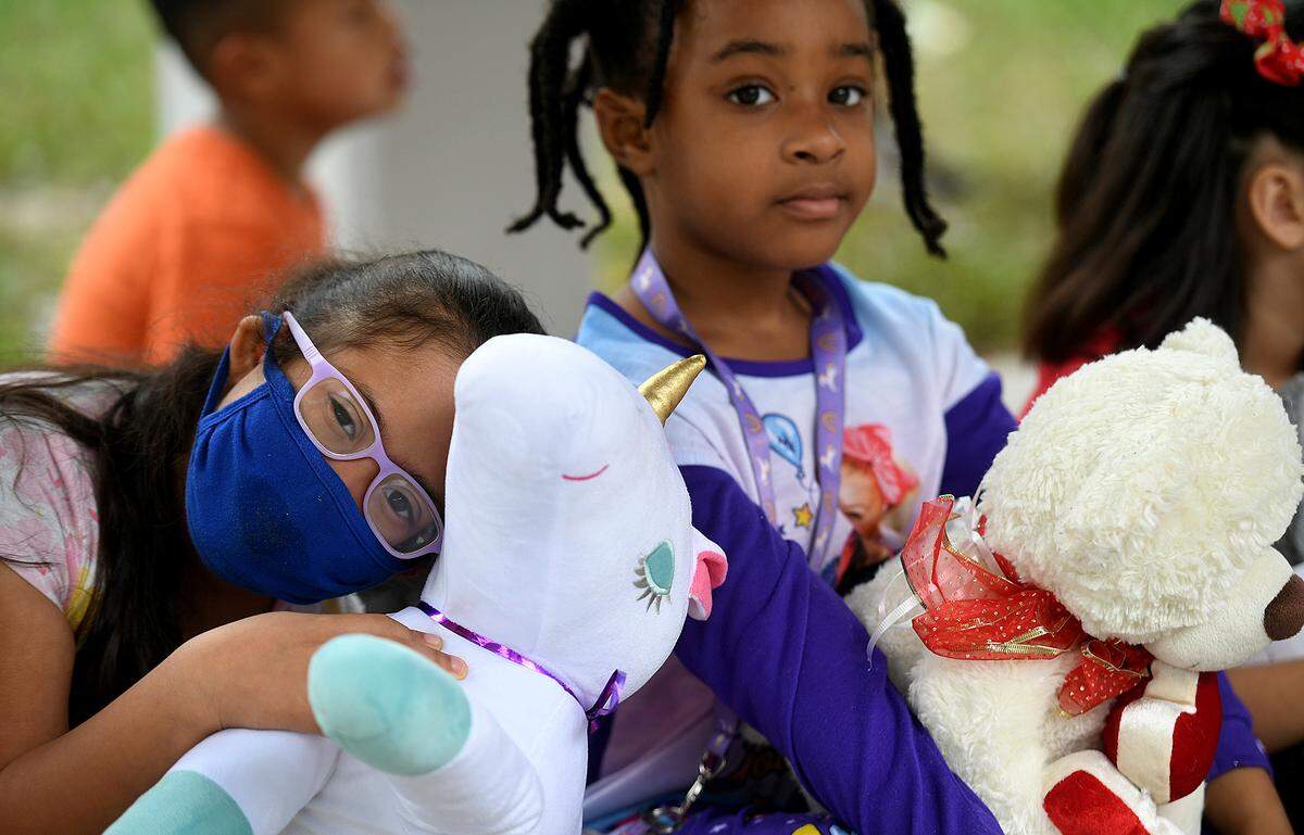 12/20/21—Lidia Garcia hugs her unicorn while Rachel Watson holds her bear. Santa arrived on an East Manatee Fire Rescue truck to delight of pre-kindergarteners and ESE students at Bashaw Elementary School.