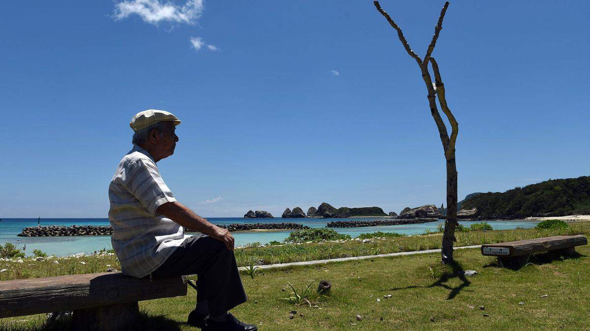 Takeichi Kakinohana, 85, lives on Aka Island where the American military landed during the Battle of Okinawa and where, eventually, the Japanese ceremonially surrendered on the beach where he sits on Aug. 1, 2015. Takeichi, conscripted by the Japanese Army at 15, hid with other islanders in the mountains for months when the Americans landed. (Tiffany Tompkins-Condie/McClatchy DC/TNS)