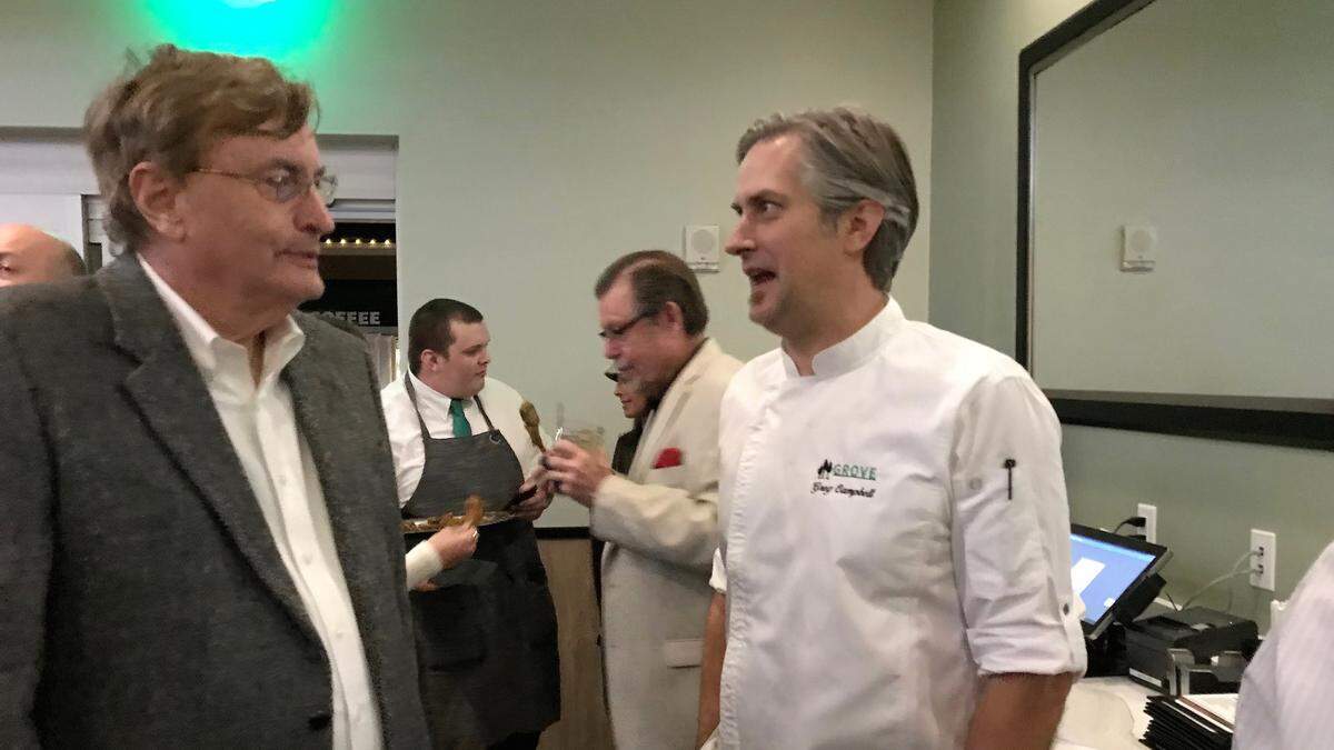 Greg Campbell, executive chef and director of operations, right, greets guests at a Grove restaurant sneak peek this week.