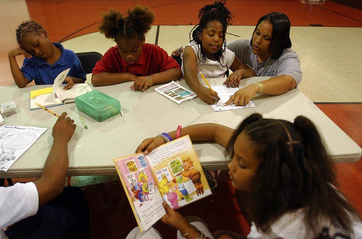 As Ladarika Pinkney, 9, reads in the foreground, Lashanice Jones, Regsene Williams (CQ) and Nadia Shepard study with Alissa Woodberry at the old 13th Avenue Community Center. The children, upon arrival after school, spend at least 30 minutes working on their homework.