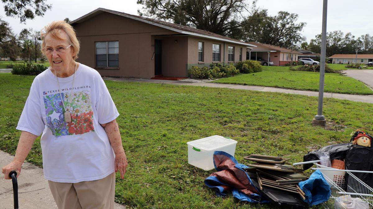 Libbie Bowers, 85, stands near the last remaining items of her shed in Bradenton, Fla., Oct. 11, 2024. Before neighbors came to help, her yard in the il Villaggio community was covered with her ruined possessions, Bowers said. (Kylie Williams/WUFT News)