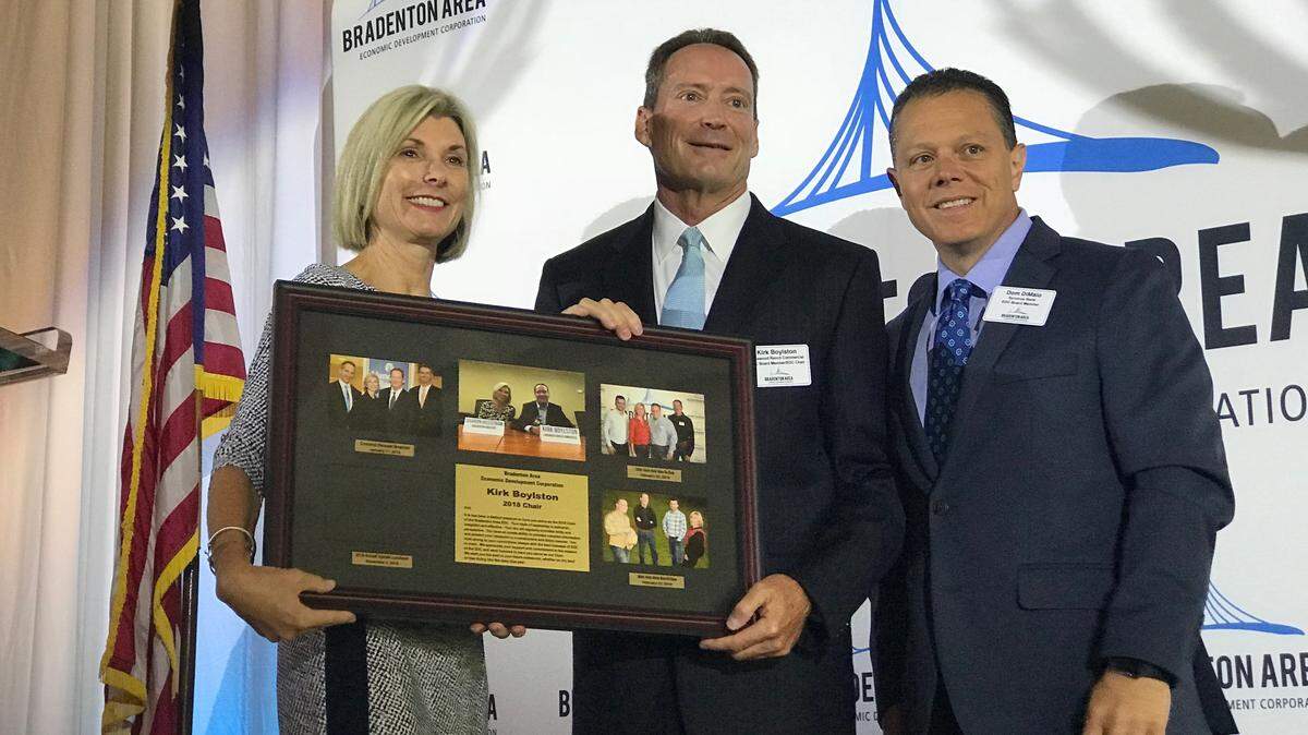 Kirk Boylston (center), outgoing chair of the Bradenton Area Economic Development Corporation, received a plaque for his service Friday during the 2018 annual update luncheon at Lakewood Ranch. Also shown are Sharon Hillstrom, president and CEO of the EDC, and Dom DiMaio, incoming EDC chair.