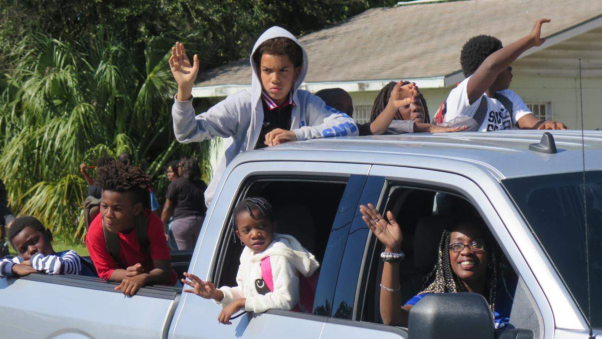 Participants wave at the crowd from a pickup truck during the Palmetto Youth Center’s annual Dr. Martin Luther King Junior Parade. The event drew thousands Saturday afternoon.