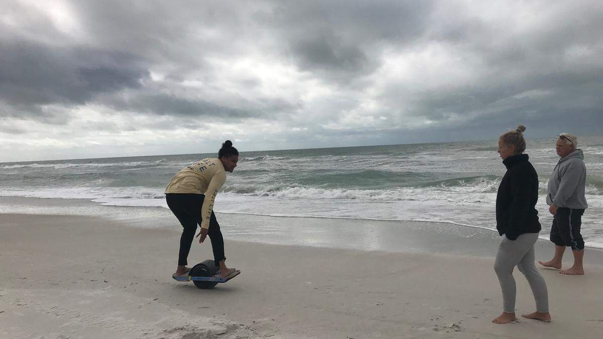 Anna Maria Island beaches may have been a little chilly for getting in the water on Monday, but the sand provided Jeremy Jackson with a place to ride his one-wheel. Looking on are Jamie Draud and Dana Draud.