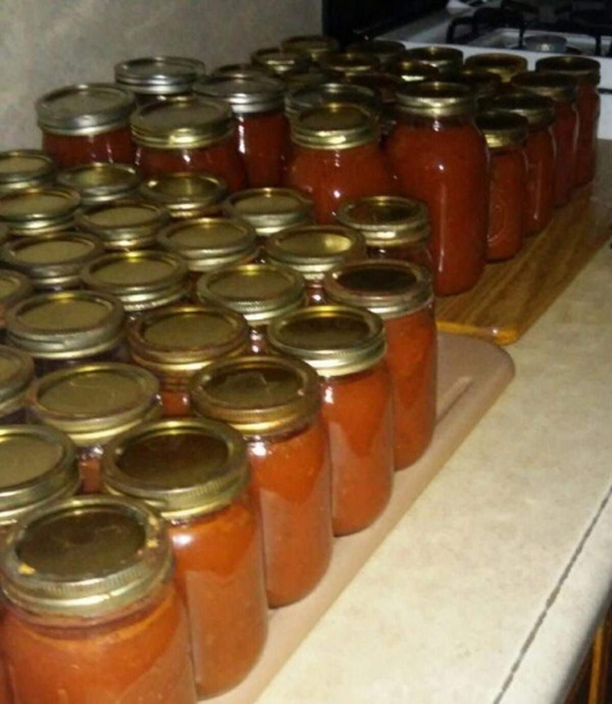 Jars of canned pizza sauce, made with fresh tomatoes from Lovina Eicher’s garden, ready to be stored for use by the family throughout the year.