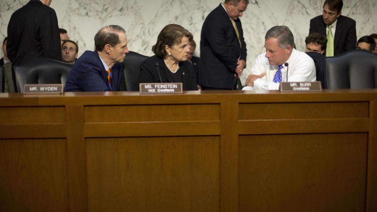 FILE - In this Sept. 24, 2015 file photo, Senate Intelligence Committee Chairman Sen. Richard Burr, R-N.C., right, confers with committee Vice-Chair. Sen. Dianne Feinstein, D-Calif., center, and committee member Sen. Ron Wyden, D-Ore., on Capitol Hill in Washington. The Senate is poised to pass a bill intended to improve cybersecurity by encouraging the sharing of threat information among companies and the U.S. government. Senators were voting on a handful of amendments Tuesday before a final vote expected later in the day on the Cybersecurity Information Sharing Act. (AP Photo/Pablo Martinez Monsivais)