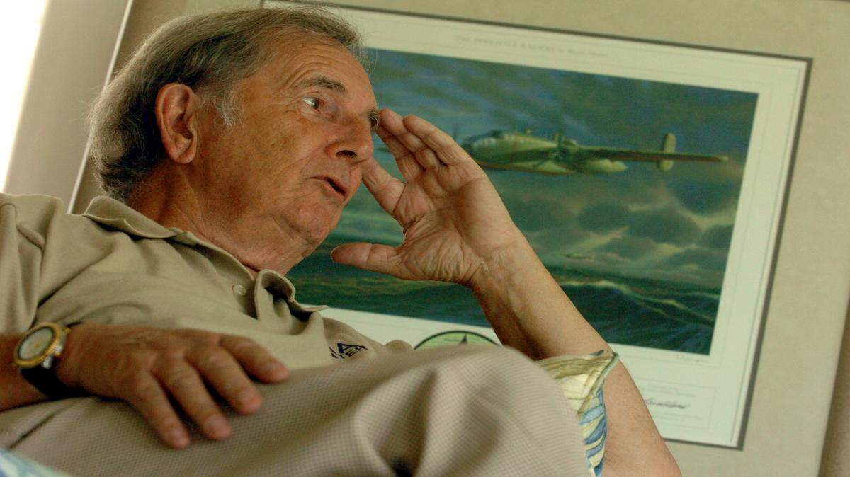 Bryan Moon tells stories in 2006 about his expeditions to find lost World War II airmen in locations around the globe. He is seated at home next to an image he painted depicting one of the Doolittle Raiders B-25 bombers which crashed in China on April 18th, 1942. Moon located some of these bombers during an expedition to China. 
 HERALD FILE PHOTO