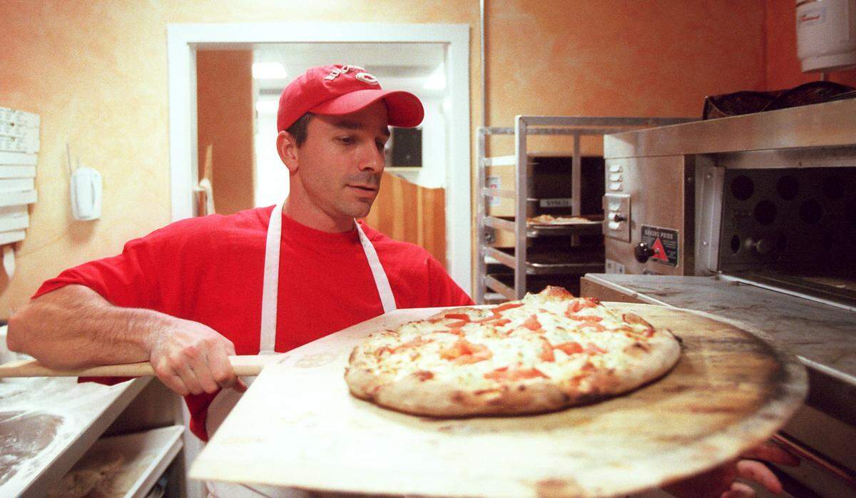 Mike Favasuli, owner of Fav’s Italian Cucina, 419 12th Street West, pulls one of his signature White Pizza’s out of the oven on Monday afternoon. Photo Alex Diaz 02.28.2000