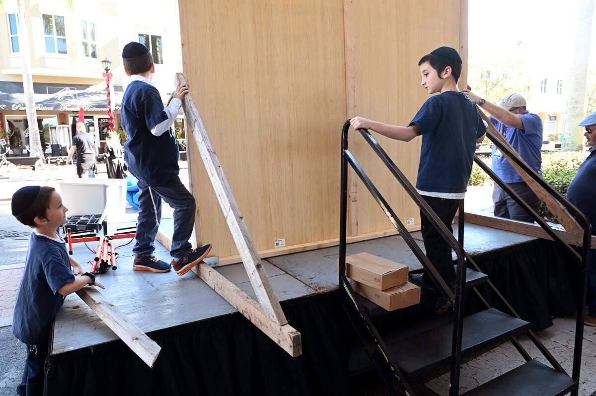 Rabbi Mendy Bukiet of the Chabad of Bradenton and Lakewood Ranch with sons Shua, Sholam, and Laibal set up what will be a large menorah for a celebration of the second night of Hanukkah on Lakewood Ranch Main Street.