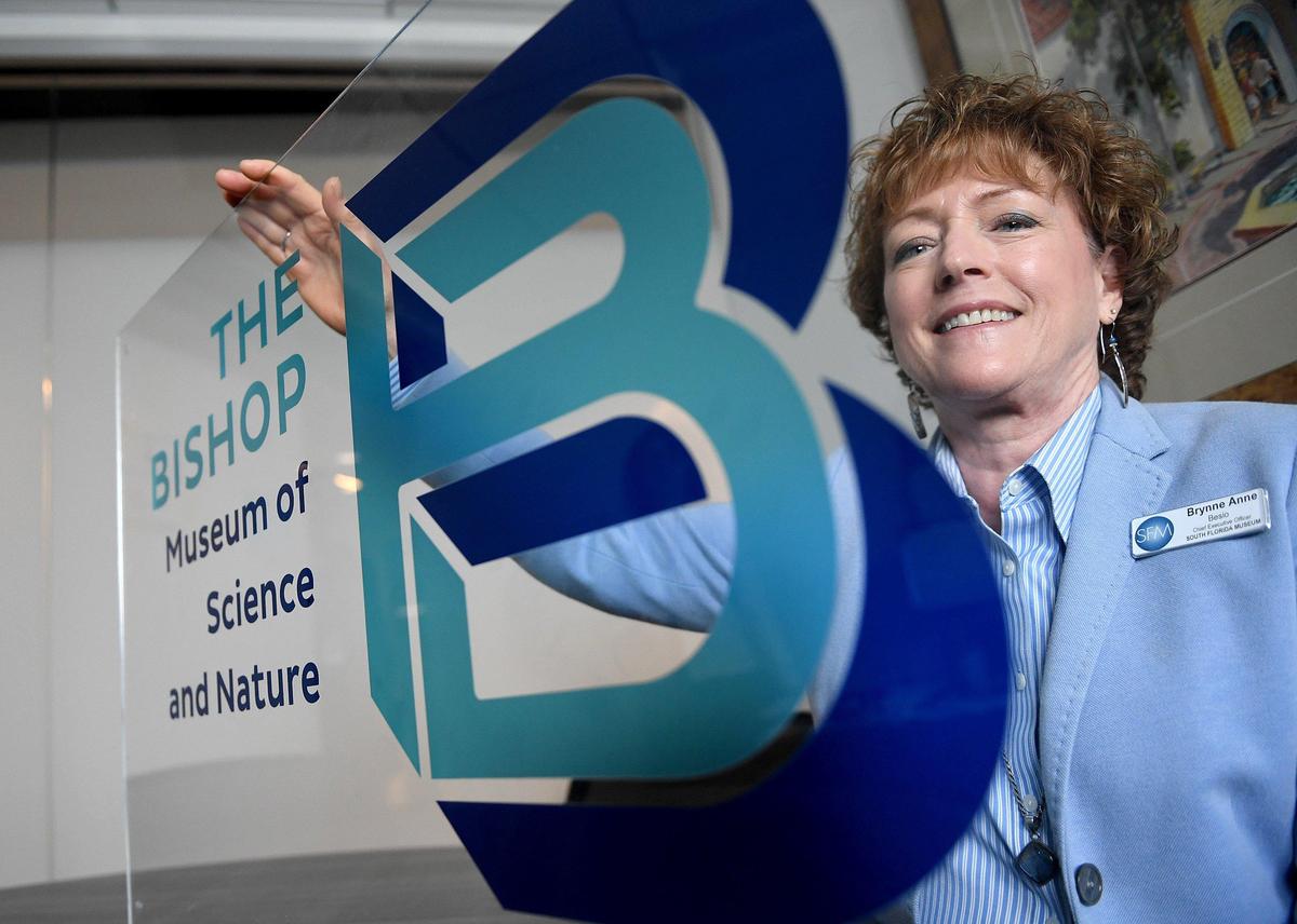 CEO Brynne Anne Besio holds a sign for the newly renamed ‘The Bishop Museum of Science and Nature,’ formerly the South Florida Museum.