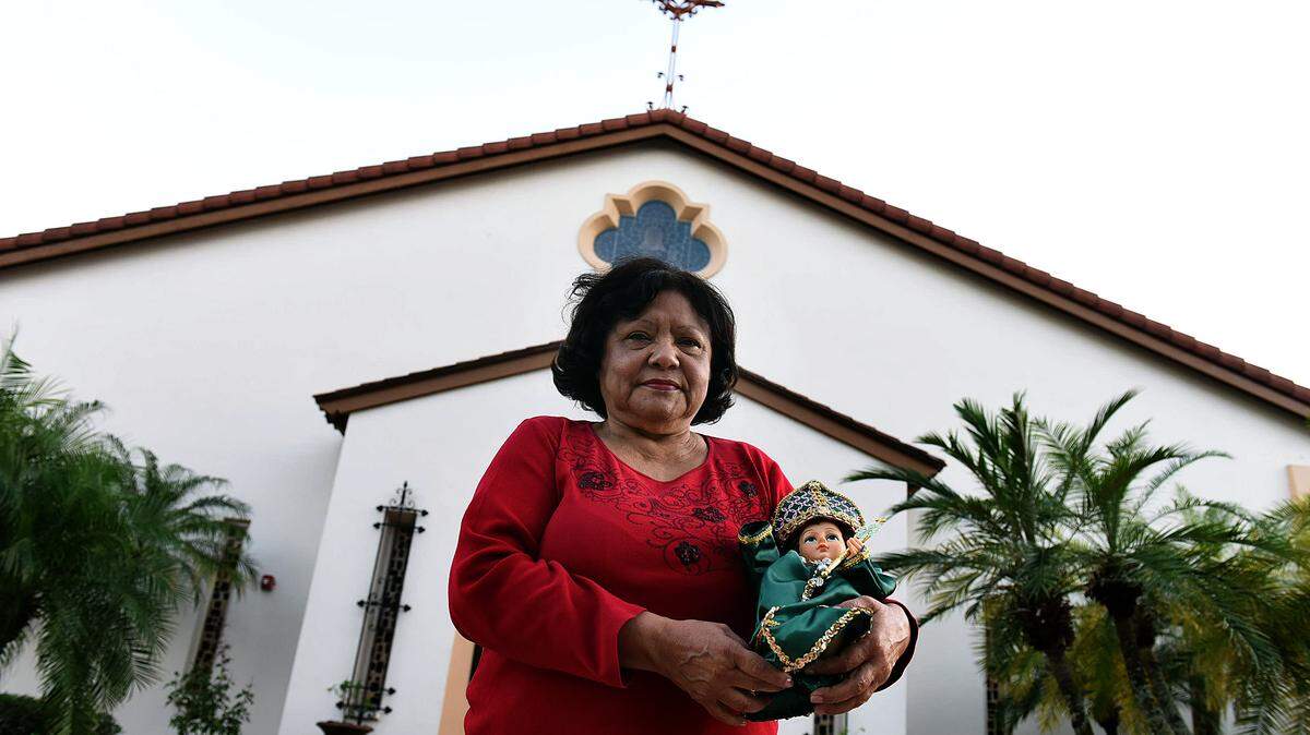Maria Cristina Pagan, 67, stands in front of Sacred Heart Roman Catholic Church Wednesday with her Baby Jesus. 
 TIFFANY TOMPKINS/Bradenton Herald