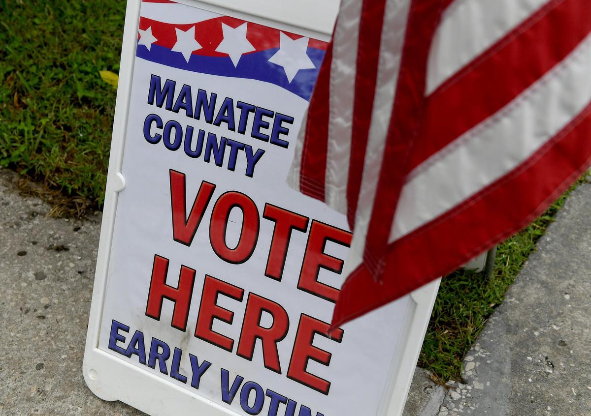 A sign and flag signals the entrance at the Manatee County Utilities Administration Offices for the first day of early voting Wednesday morning.