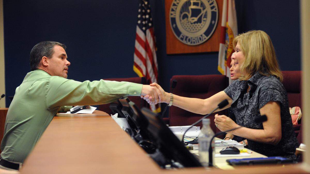 Charlie Kennedy, Manatee County School Board, shakes hands with commissioners Robin DiSabatino and Carol Whitmore, after a vote by the commission to support a recommendation by the school board to reinstate impact fees to pay for schools in January 2016. 
 GRANT JEFFERIES/Bradenton Herald